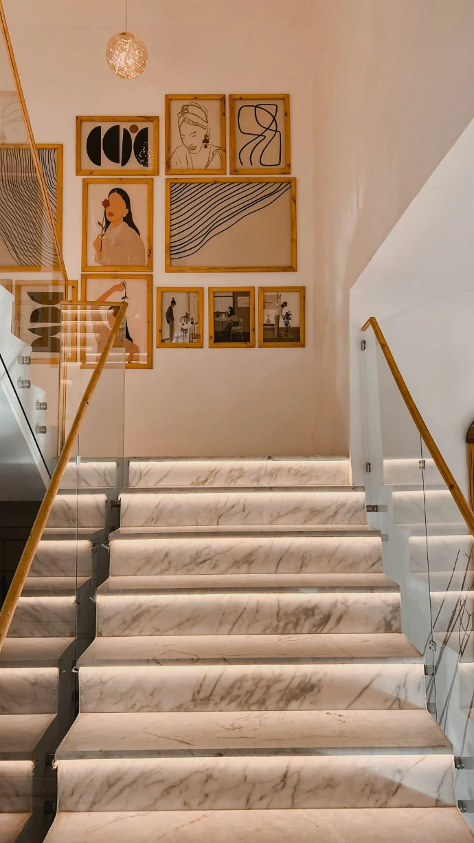 a staircase with a wall of paintings